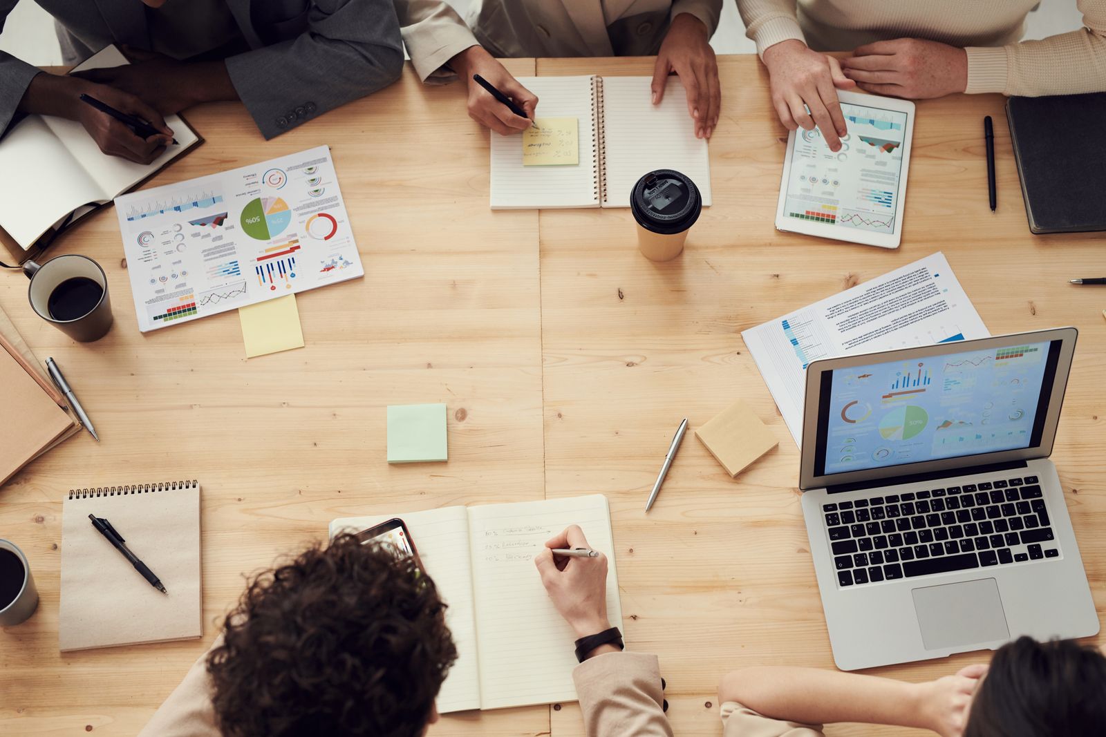 Đội ngũ marketing đang họp bàn kế hoạch với máy tính và biểu đồ in trên bàn